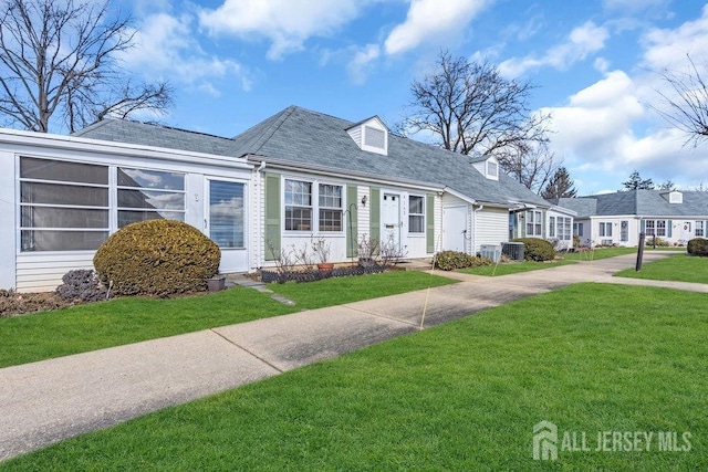 cape cod house featuring central AC and a front lawn