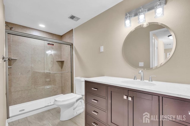 full bathroom with toilet, a shower stall, visible vents, and vanity