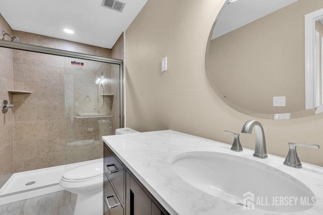 bathroom featuring a stall shower, visible vents, vanity, and toilet