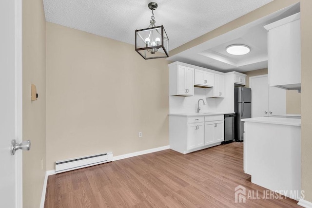 kitchen featuring a baseboard radiator, light countertops, light wood-type flooring, freestanding refrigerator, and dishwasher