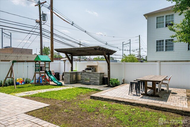 1142 Warren St, Roselle, NJ 07203 - fenced backyard with a patio, area for grilling, a playground, and outdoor dining space