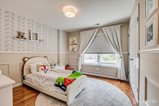 1142 Warren St, Roselle, NJ 07203 - bedroom with wallpapered walls, wood finished floors, and wainscoting