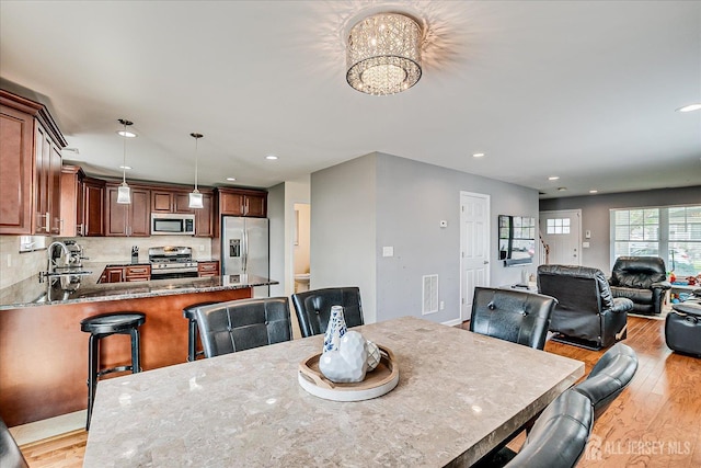 1142 Warren St, Roselle, NJ 07203 - dining room with light wood-style floors, a chandelier, and recessed lighting