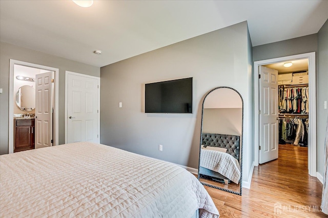 1142 Warren St, Roselle, NJ 07203 - bedroom with light wood-type flooring, a walk in closet, and ensuite bathroom