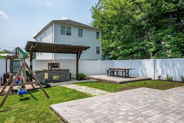 1142 Warren St, Roselle, NJ 07203 - back of property with a patio, an outdoor kitchen, and a playground