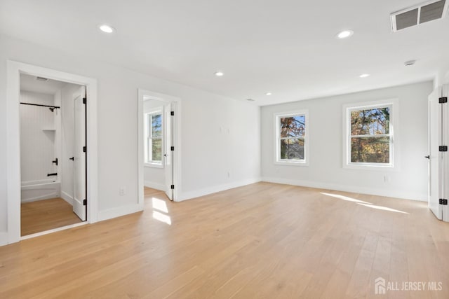 empty room featuring a wealth of natural light and light wood-type flooring