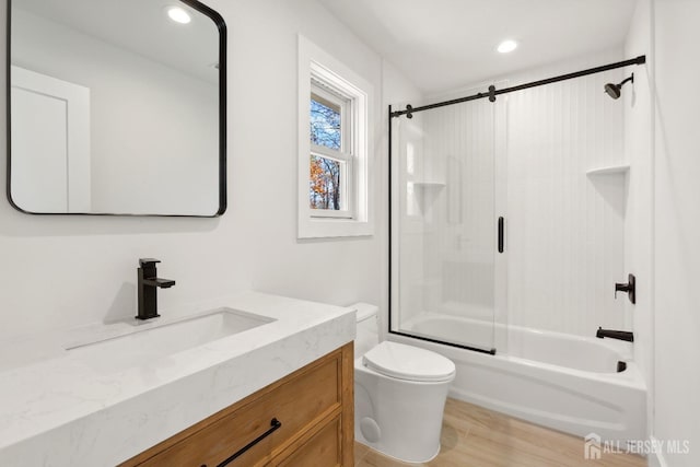 full bathroom with vanity, toilet, combined bath / shower with glass door, and wood-type flooring