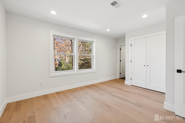 unfurnished bedroom with a closet and light wood-type flooring