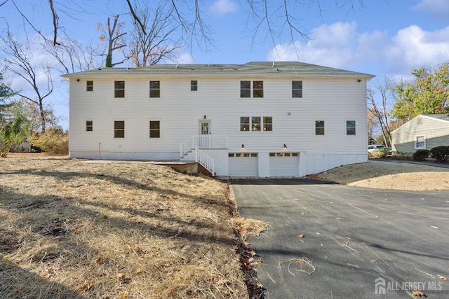 rear view of house featuring a garage