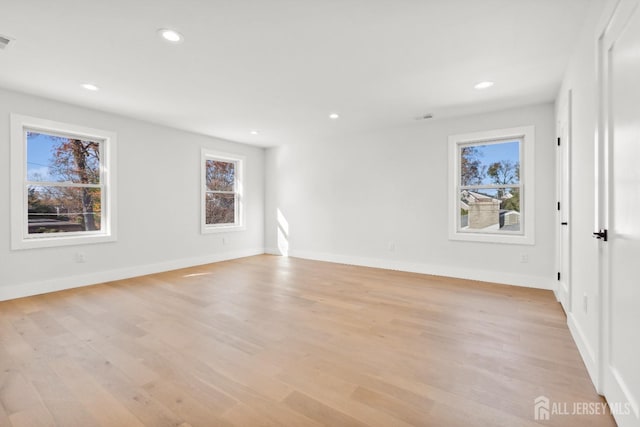 spare room featuring light hardwood / wood-style floors and a healthy amount of sunlight