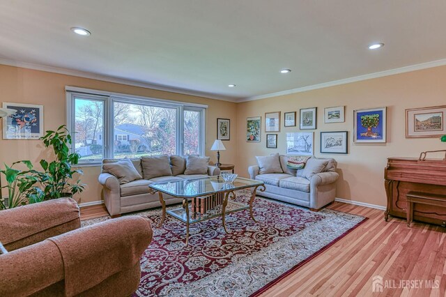 living area featuring light wood finished floors, baseboards, ornamental molding, and recessed lighting