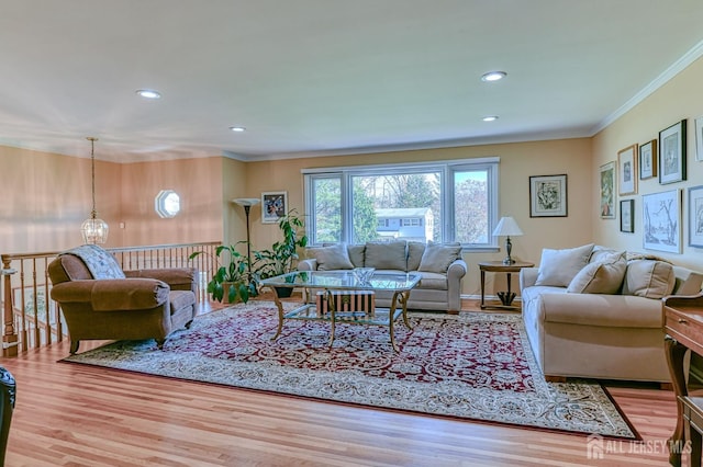 living area with ornamental molding, a chandelier, wood finished floors, and recessed lighting