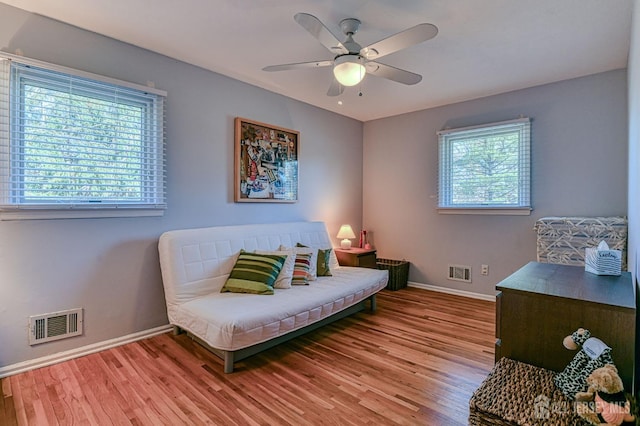 living area featuring wood finished floors, visible vents, and baseboards