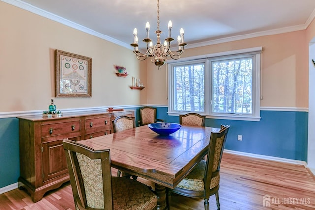 dining area with ornamental molding, light wood-style flooring, and baseboards