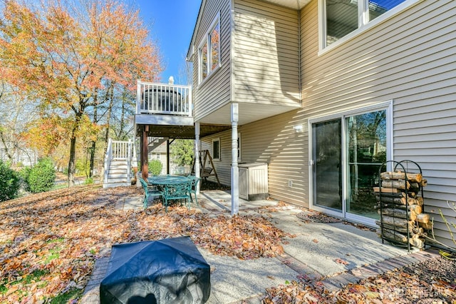 exterior space featuring stairs, outdoor dining area, and a patio