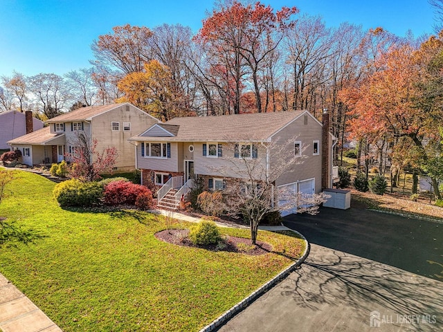 bi-level home with a garage and a front yard