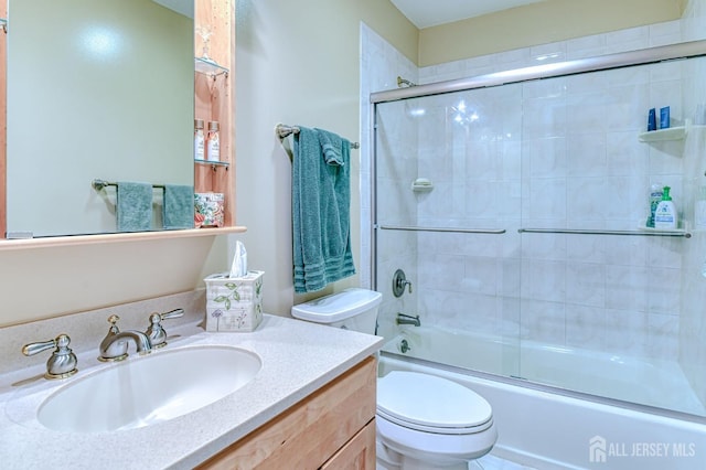 bathroom featuring shower / bath combination with glass door, vanity, and toilet