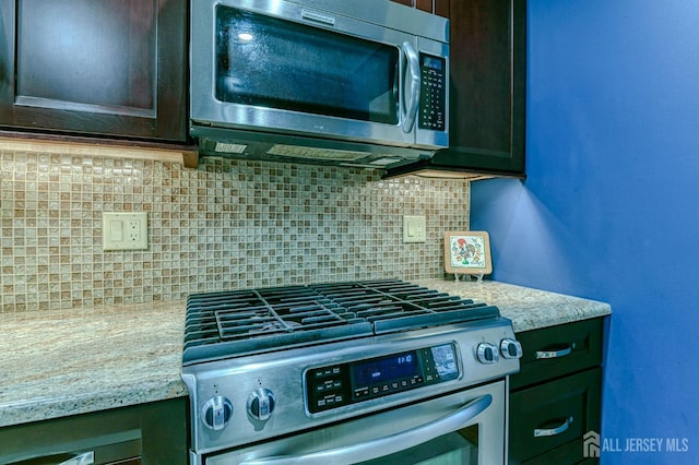 kitchen featuring stainless steel appliances, dark brown cabinetry, light stone counters, and decorative backsplash