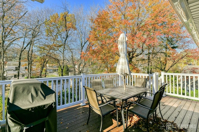 deck with outdoor dining space and grilling area