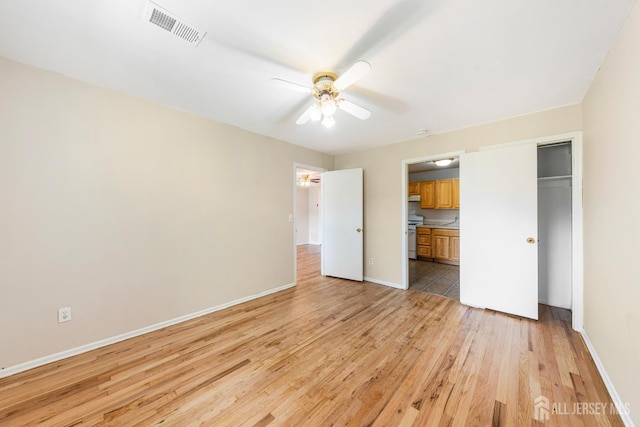 227 College Dr, Edison, NJ 08817 - unfurnished bedroom with light wood-type flooring, a closet, connected bathroom, and ceiling fan