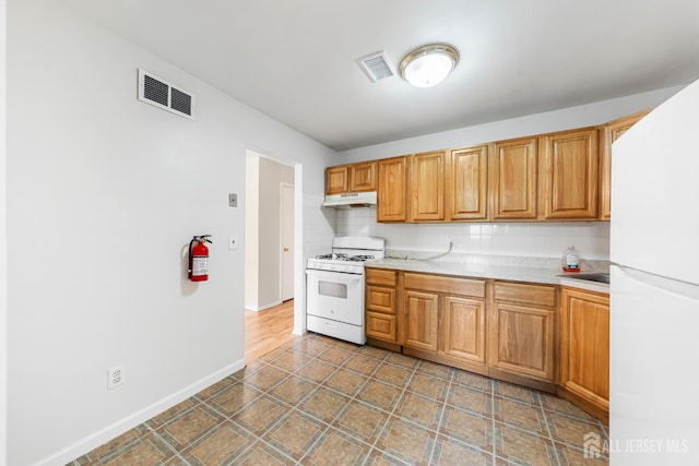 227 College Dr, Edison, NJ 08817 - kitchen with white appliances, backsplash, light countertops, and under cabinet range hood