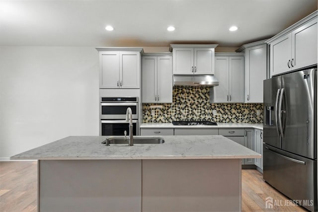 30 Clover Ln, Monroe, NJ 08831 - kitchen with stainless steel appliances, gray cabinetry, under cabinet range hood, backsplash, and light stone countertops