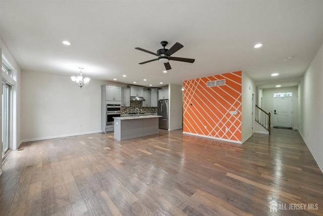30 Clover Ln, Monroe, NJ 08831 - unfurnished living room with a chandelier, dark wood finished floors, a ceiling fan, recessed lighting, and healthy amount of natural light