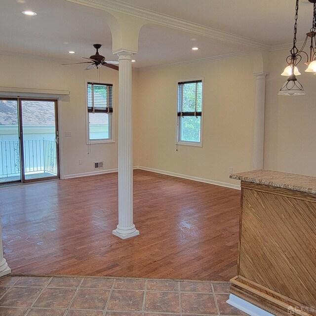 spare room with crown molding, decorative columns, and ceiling fan