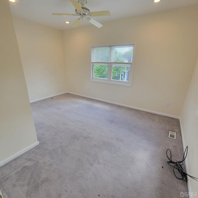 unfurnished room featuring ceiling fan and light colored carpet