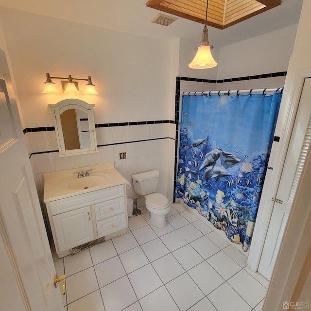 bathroom with toilet, tile walls, vanity, a shower with shower curtain, and tile patterned flooring