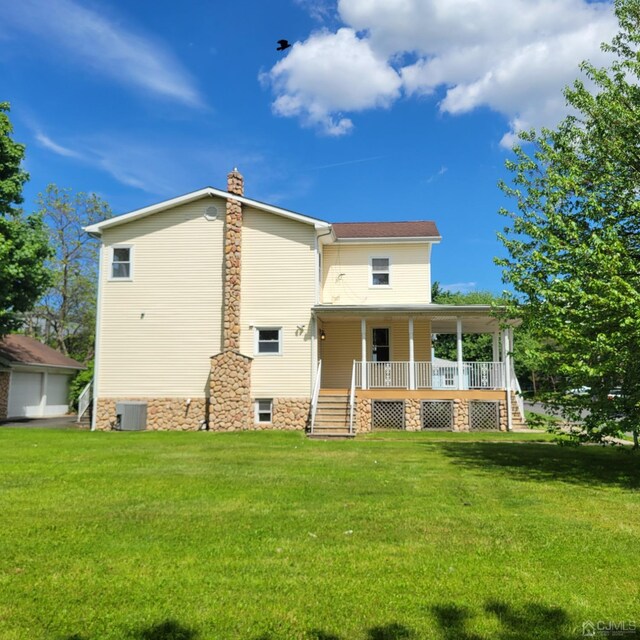 back of property featuring central air condition unit, covered porch, and a lawn