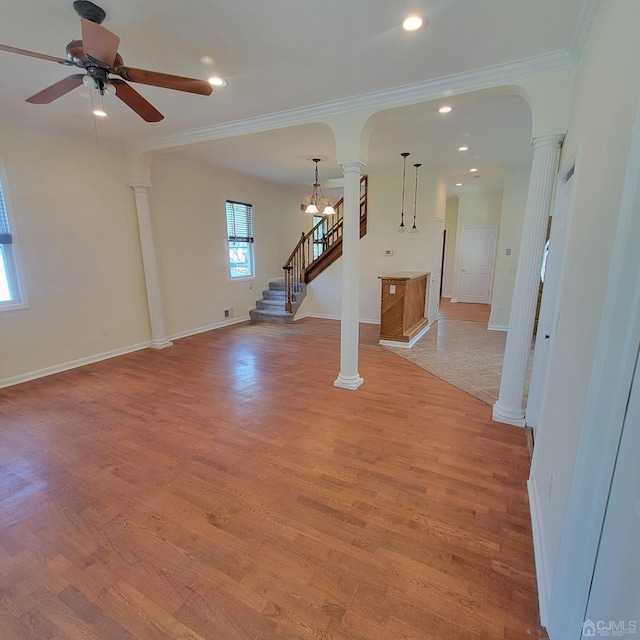 unfurnished living room with crown molding, light hardwood / wood-style flooring, ceiling fan, and ornate columns