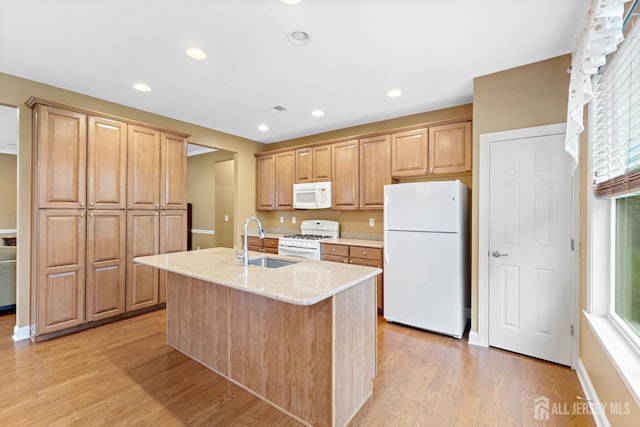 72 Wintergreen Dr, Manalapan, NJ 07726 - kitchen with white appliances, a sink, light stone counters, light wood-style floors, and a kitchen island with sink