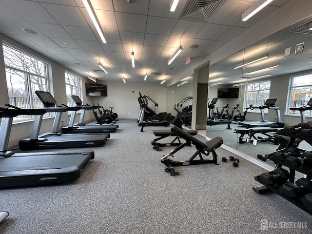 workout area with a paneled ceiling, visible vents, and baseboards