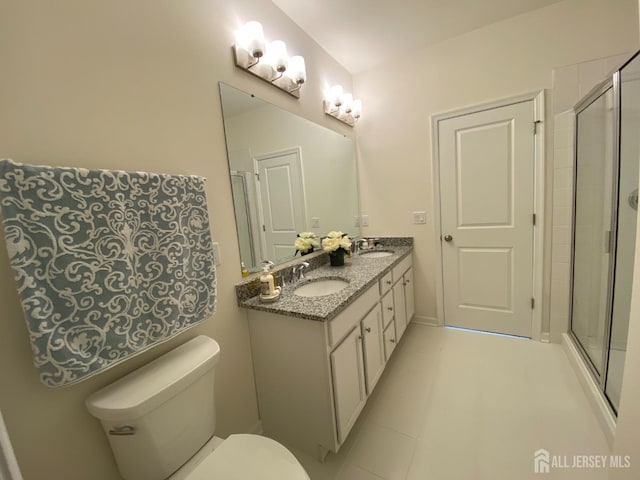 bathroom with a shower stall, toilet, and a sink