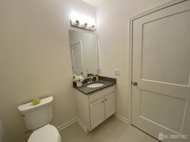 bathroom with tile patterned flooring, toilet, vanity, and baseboards