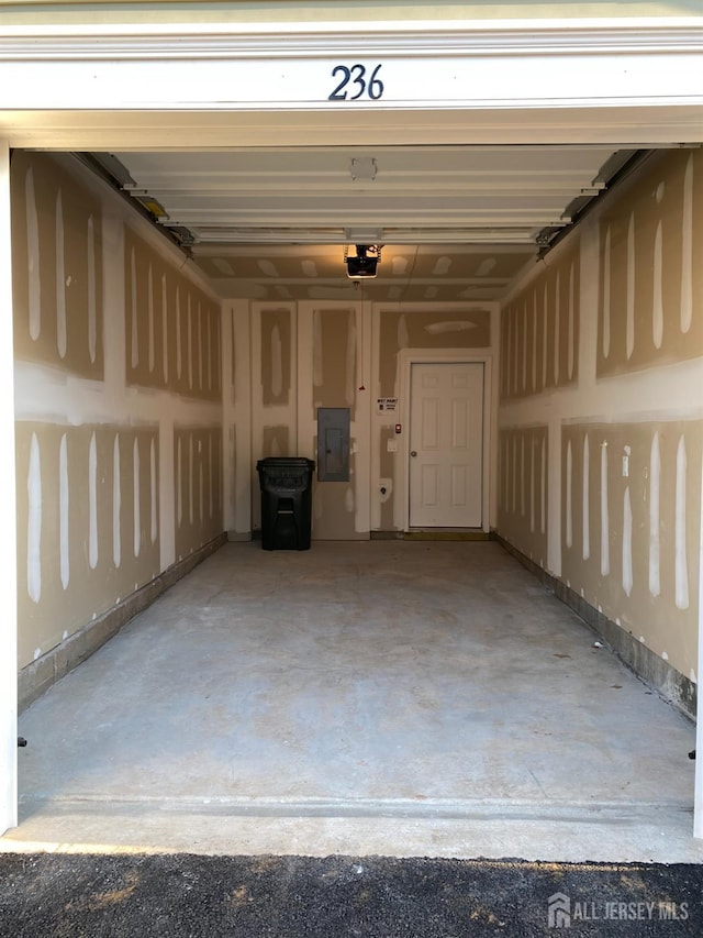 garage with electric panel and a garage door opener