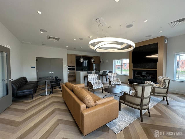 living area featuring a wealth of natural light, visible vents, and recessed lighting