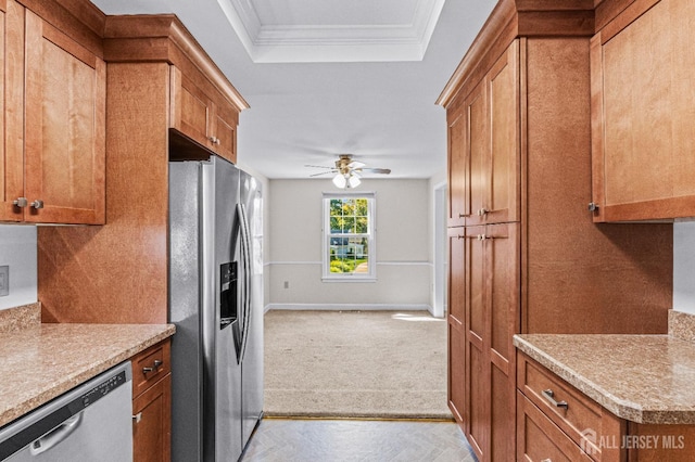 kitchen featuring ceiling fan, stainless steel appliances, crown molding, a tray ceiling, and light carpet