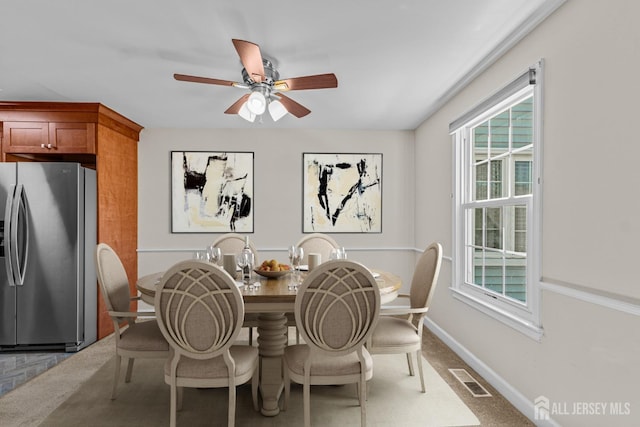 dining space with baseboards, visible vents, and a ceiling fan