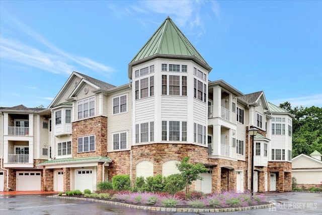 4215 Falston Cir Unit 15, Old Bridge, NJ 08857 - view of front of home with stone siding, a standing seam roof, an attached garage, a metal roof, and driveway