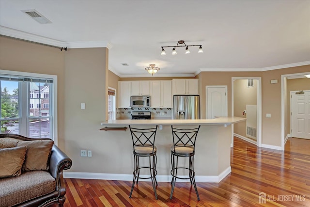 4215 Falston Cir Unit 15, Old Bridge, NJ 08857 - kitchen featuring appliances with stainless steel finishes, a breakfast bar, light wood-type flooring, white cabinetry, and light countertops