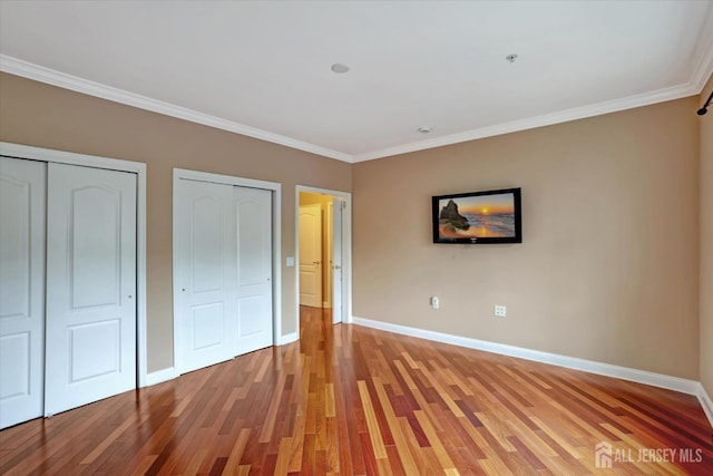 4215 Falston Cir Unit 15, Old Bridge, NJ 08857 - unfurnished bedroom with two closets, light wood-style flooring, and ornamental molding