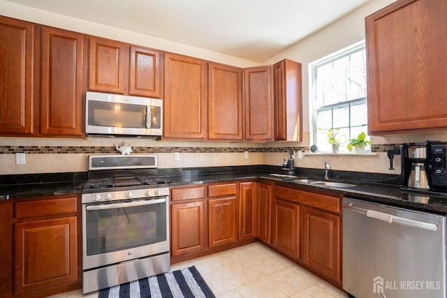 460 Morning Glory Dr, Monroe, NJ 08831 - kitchen featuring stainless steel appliances, a sink, decorative backsplash, brown cabinetry, and dark stone counters