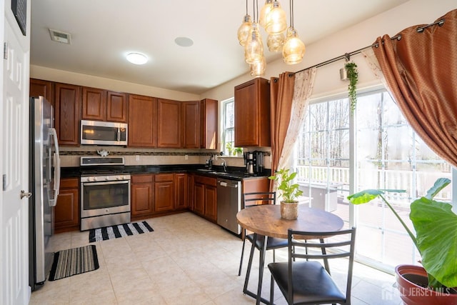 460 Morning Glory Dr, Monroe, NJ 08831 - kitchen featuring appliances with stainless steel finishes, dark countertops, brown cabinetry, and tasteful backsplash