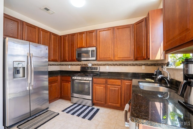 460 Morning Glory Dr, Monroe, NJ 08831 - kitchen with appliances with stainless steel finishes, a sink, backsplash, brown cabinets, and dark stone countertops
