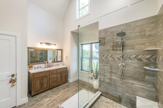 bathroom featuring plenty of natural light, vanity, hardwood / wood-style floors, and tiled shower