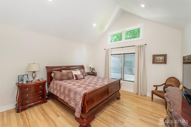 bedroom with high vaulted ceiling and light hardwood / wood-style flooring