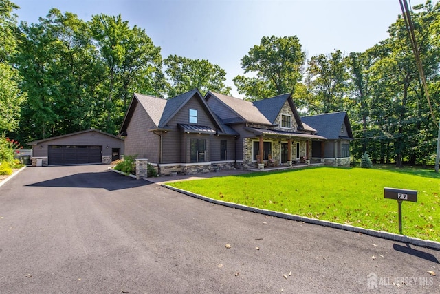 view of front of home featuring a garage, an outdoor structure, and a front yard