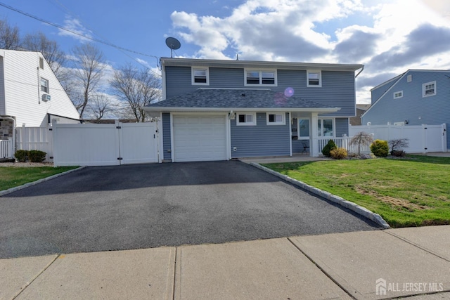 117 Whitman St, Carteret, NJ 07008 - view of front of home featuring a front lawn, a garage, a gate, aphalt driveway, and fence